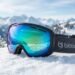 Snow skiing goggles and bib gear on a bright mountain slope with UV protection emphasis