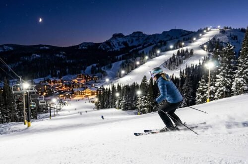 Illuminated ski slopes at Brian Head Resort during a night skiing session under bright lights against a dark Utah sky