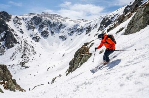 Skiers ascending the Tuckerman Ravine Trail on Mount Washington with the steep headwall visible above the ravine floor