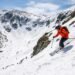 Skiers ascending the Tuckerman Ravine Trail on Mount Washington with the steep headwall visible above the ravine floor