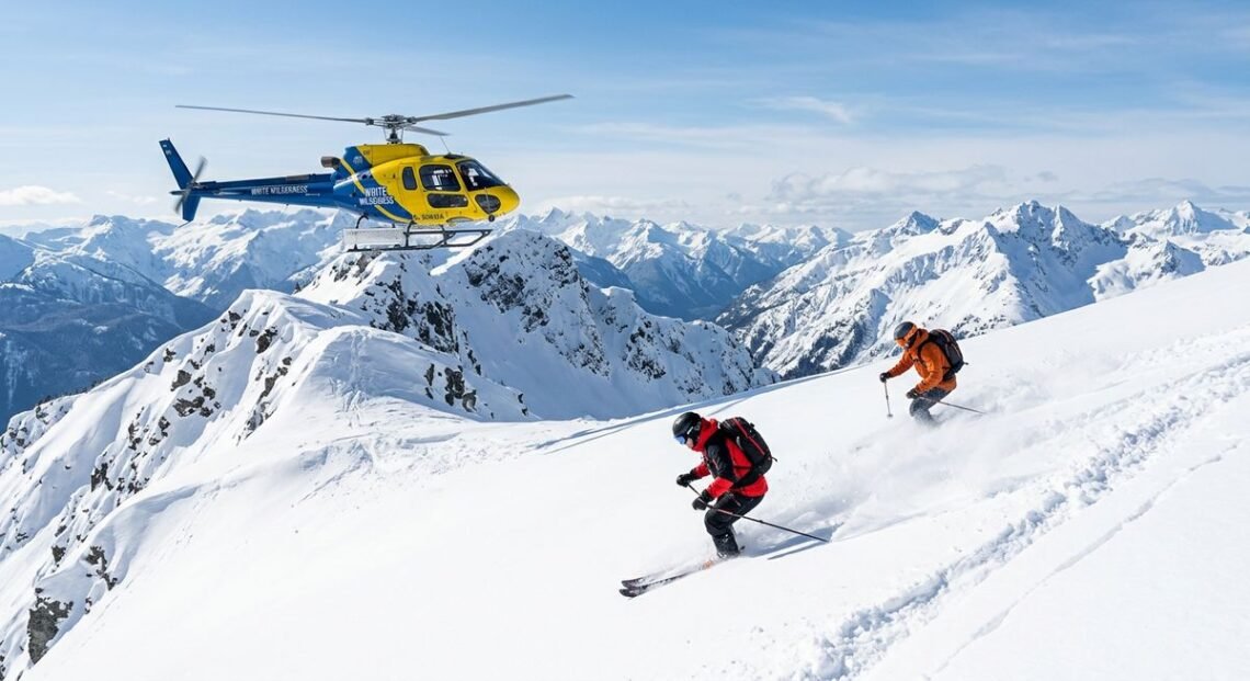 white wilderness heli skiing operation near Terrace BC with Coast Mountain backdrop and helicopter on snow