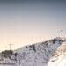 Gondola cables crossing a snowy mountain ridge under a clear sky ahead of the 2026-2027 winter weather predictions season
