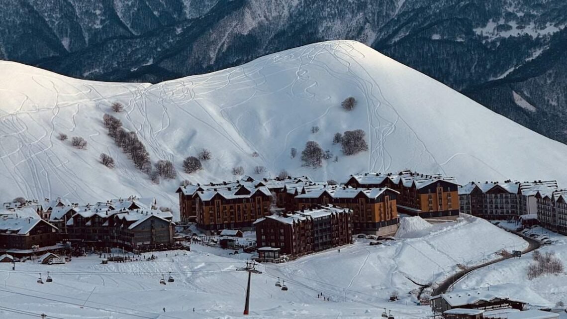 Ski resort village lodges at the base of a snowy mountain, the lodging line in how much does a ski trip cost