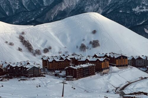Ski resort village lodges at the base of a snowy mountain, the lodging line in how much does a ski trip cost